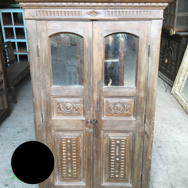 Vintage carved cupboard door in frame with glass windows